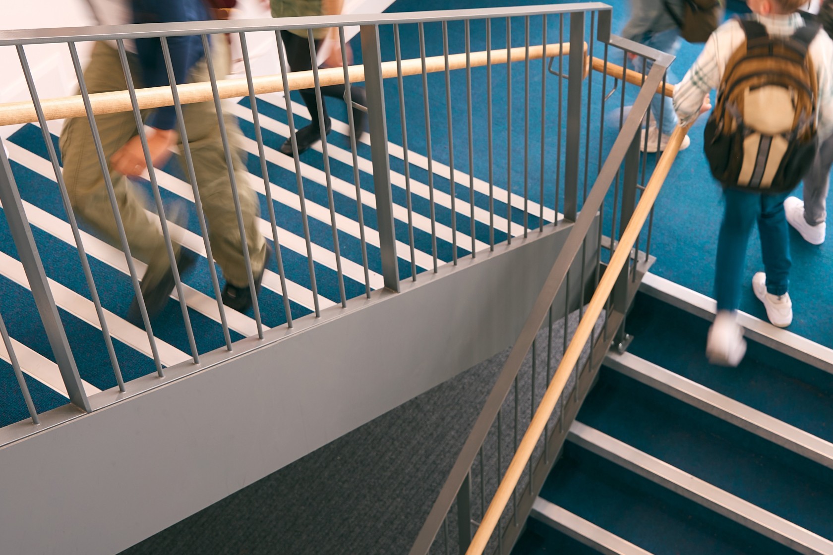 Group Of Secondary Or High School Pupils Inside School Building On Stairs With Motion Blur