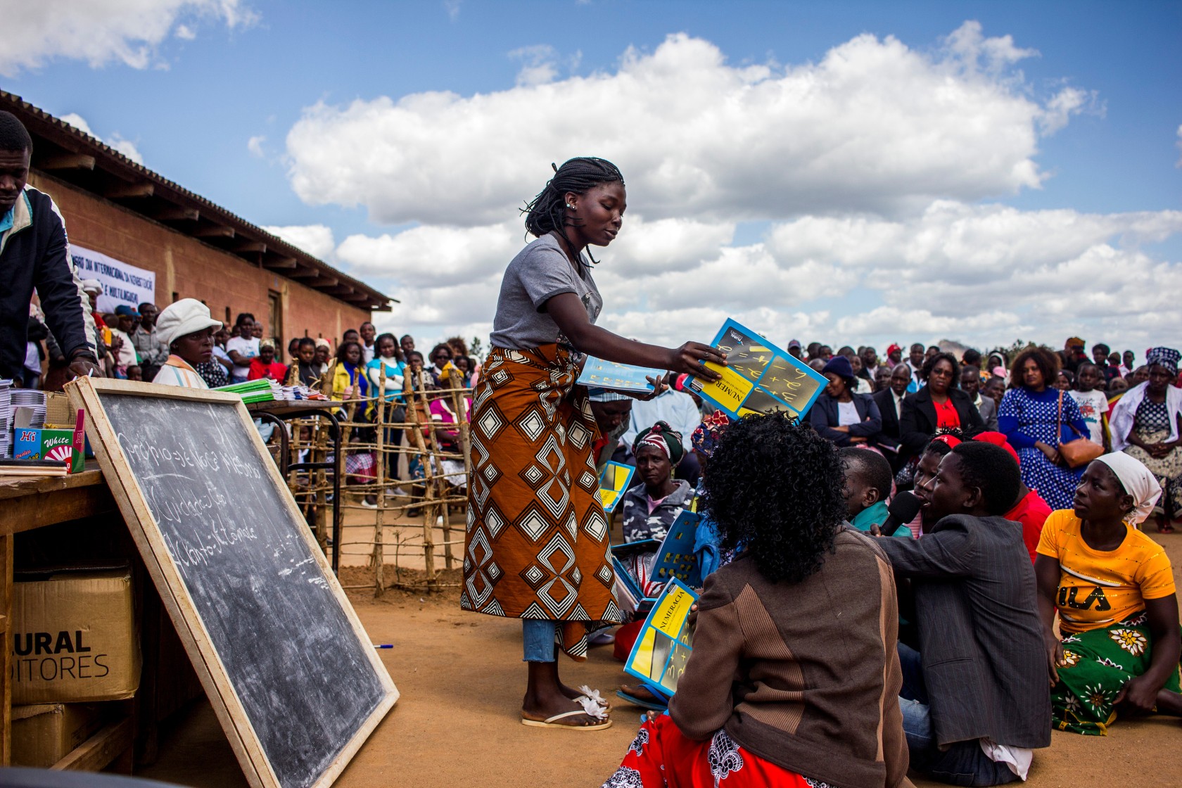 Manica, Mozambique-  September 08, 2019: Woman giving numeracy books on International Literacy Day