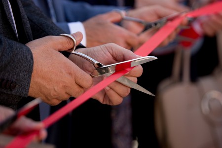Businessmen hands cutting red ribbon close-up, new project, opening ceremony, stock footage